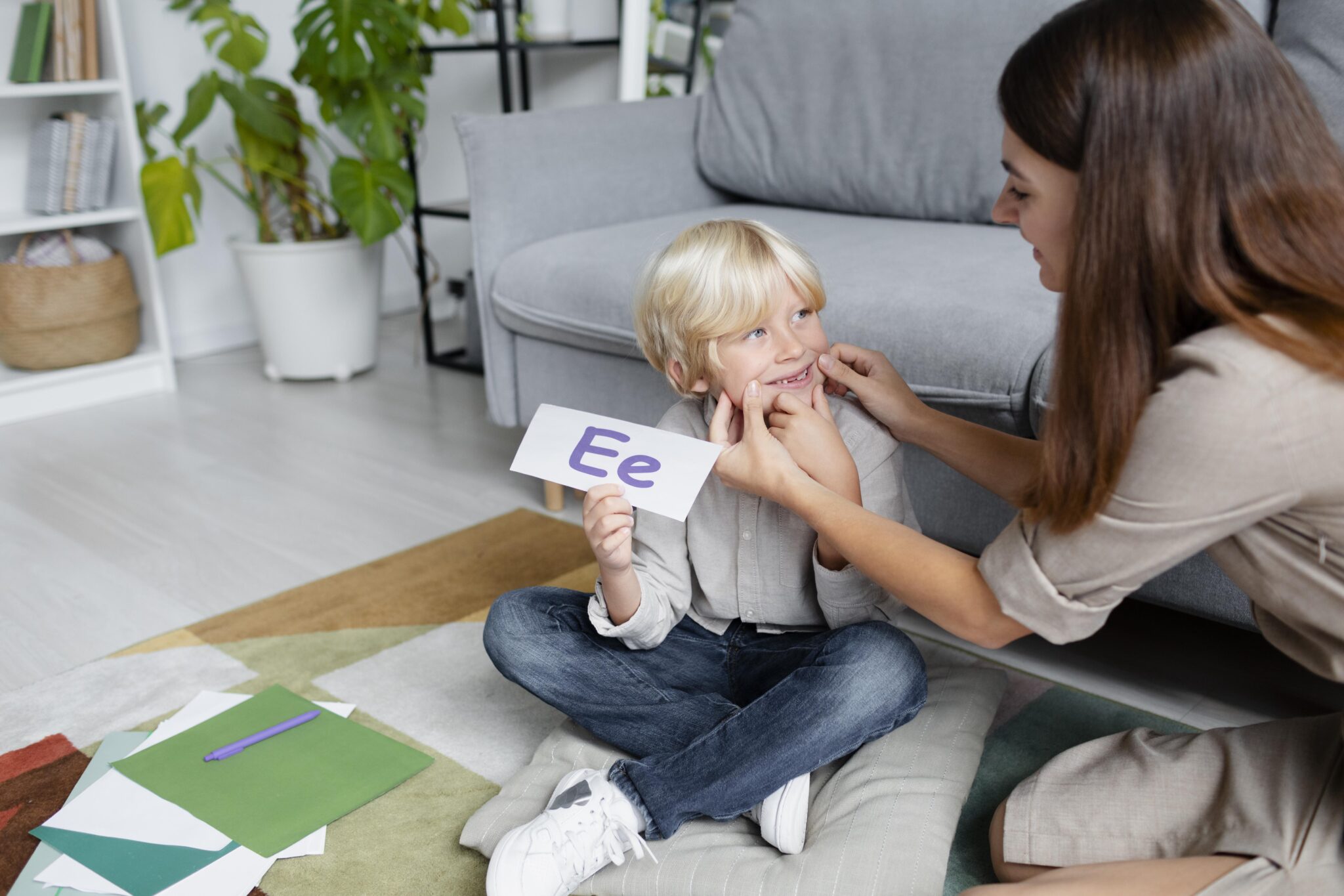 young woman doing speech therapy with little blonde boy